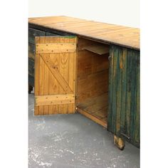 an old wooden table with a sliding door on the top and bottom part open to reveal a storage compartment