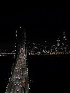 cars are driving over the bay bridge at night