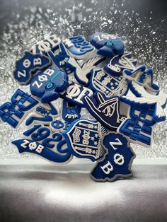 blue and white decorated cookies are in a glass vase with silver glitters behind them