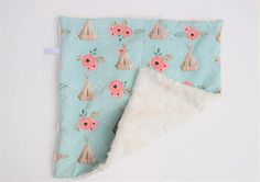 a piece of cloth with flowers and teepees on it next to a pillow