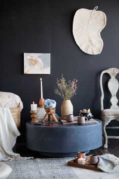 a living room filled with furniture and decor on top of a carpeted floor next to a wall