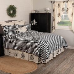 a black and white checkered bedspread in a room with wood flooring