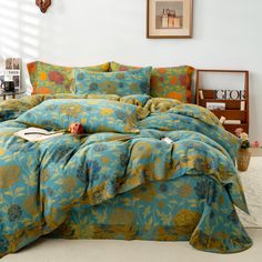 a bed with blue and green floral comforter set