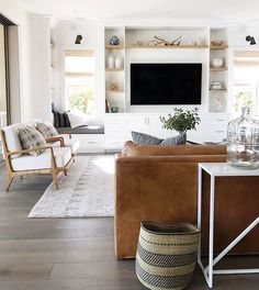 a living room filled with furniture and a flat screen tv mounted on a wall above a fireplace