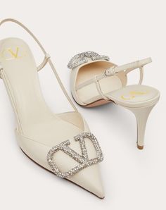 Valentino Garavani slingback pump in calfskin leather with VLogo Signature embellishment. - VLogo Signature accessory with crystal appliqués - Heel height: 80 mm / 3.1 in. - Made in Italy Luxury High Heel Slingback Pumps, Designer Formal Slingback Pumps With Crystals, White Calf Leather Slingback Pumps For Evening, Designer Crystal-embellished Slingback Pumps For Formal Occasions, Luxury Crystal Embellished Slingback Pumps, Elegant White Calf Leather Slingback Pumps, Luxury High Heel Slingback Pumps For Gala, Luxury Cream Slingback Pumps With Pointed Toe, Luxury Calf Leather Slingback Pumps With Heel Strap