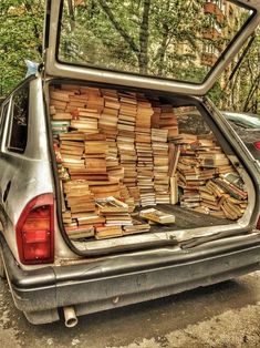 an old car is loaded with books in the back