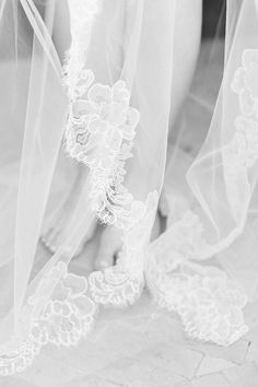 black and white photo of bride's shoes with veils on the bottom floor