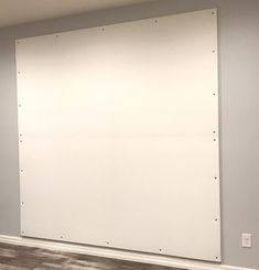 an empty room with a large white board on the wall