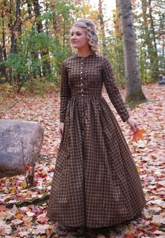 This attractive dress has a jewel neckline, front button closure and long sleeves. This dress also features our three-paneled full skirt with pockets. Hand wash or machine wash and dry gently. 100% sturdy cotton. The model is wearing boots, and a crinoline, which are priced separately. Designed and made proudly by Recollections in America! The following are approximate finished measurements and include room for ease of movement.  BustWaist (in inches) XS36.528 S39        29.5 M41        31.5 L45 Pioneer Work Dress, Long Sleeve Prairie Dress For Daywear, Modest Cotton Dresses For Fall, Classic Fall Dresses With Covered Buttons, Fitted Long Sleeve Prairie Dress With Buttons, Classic Dresses With Covered Buttons For Fall, Long Sleeve Dresses With Covered Buttons For Fall, Cotton Prairie Dress For Fall Daywear, Fitted Brown Prairie Dress For Fall