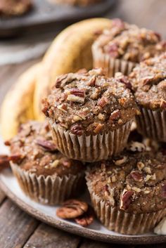 several muffins are stacked on top of each other with pecans in the background