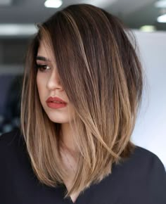 a woman with brown hair and red lipstick is looking off to the side while wearing a black shirt