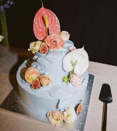 there is a cake with flowers on it and a knife next to the cake plate