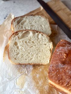 two loaves of bread sitting on top of a cutting board next to a knife