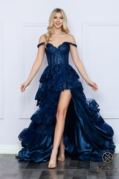 Elevate your formalwear with the Nox Anabel R1299 Prom Dress. This elegant gown features a corset-style bodice, off-the-shoulder neckline, and intricate lace and sequin detailing. The high slit skirt adds a touch of drama, making this dress perfect for prom or any special occasion. Ruffle layered skirt and train with Detailed lace embellished hems. Sizes: 0-16 Colors: Blush, Fuchsia, Light Blue, Navy Blue, Periwinkle Cool Prom Dresses Unique, Prom Dress 2025, Dramatic Prom Dresses, Corset Prom Dress Long, Prom Dress Corset, Designer Formal Dresses, Sheer Corset, Navy Blue Prom Dresses, Blue Periwinkle