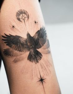 a black and white photo of a bird on the back of a woman's arm