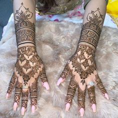 two hands with henna tattoos on them