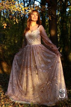 a woman in a long dress is posing for the camera with her hands on her hips