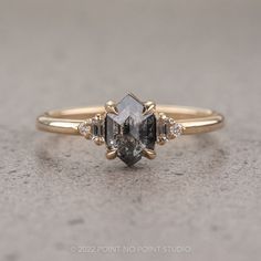 a diamond ring with three stone accents on the side and two diamonds in the middle