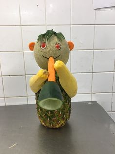 a pineapple shaped like a man holding a carrot in his mouth