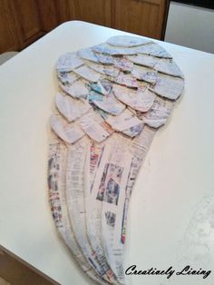 an angel wings made out of newspapers sitting on top of a counter