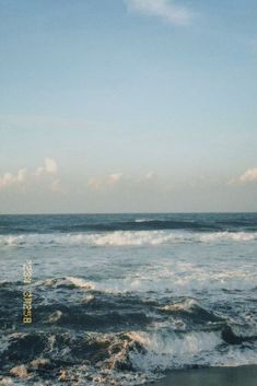 an ocean view with waves crashing on the shore