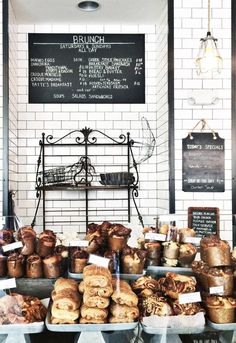 breads and pastries are on display at the bakery's front counter, along with chalkboard menus