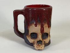 a ceramic mug with a skull on it's side and blood dripping down the inside