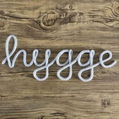 the word hygge written in rope on a wooden surface