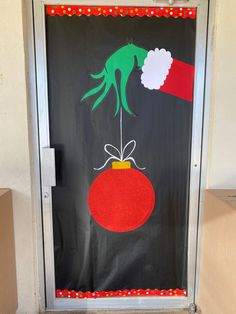 a door decorated to look like an ornament with a hand holding a christmas ball