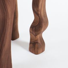 a wooden stool made out of wood with two legs and one foot on the ground