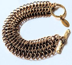 Our chic and slinky 7" long and 3/4" wide brass European 4 in 1 chain maille cuff bracelet shimmers like gold and feels as beautiful as it looks with a substantial yet comfortable weight. Finished with a 24k gold-plated pewter toggle clasp, this is a striking accessory for special occasions and adds a pop of golden pizzazz to everyday outfits.  * Signature SUZANNA gold charm. * Arrives in a black satin drawstring pouch. * Free shipping worldwide. Chain Maille Bracelet, Chainmaille Bracelet, Satin Noir, Chain Maille, Drawstring Pouch, Bracelet Clasps, 4 In 1, Toggle Clasp, Gold Charm