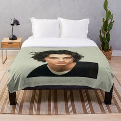 a person with long hair on a bed in a room next to a potted plant