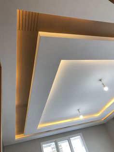 an empty room with white walls and lights on the ceiling is lit by recessed lighting