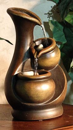 a bronze vase with water pouring out of it