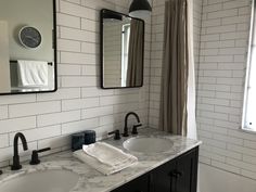 a bathroom with two sinks and mirrors in it