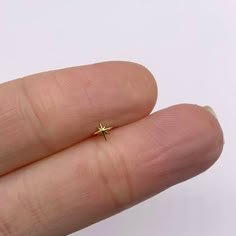 a person's finger with a tiny star ring on it