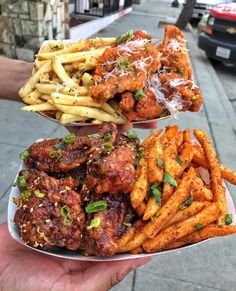 two plates filled with different types of food on a street side walk next to a sidewalk