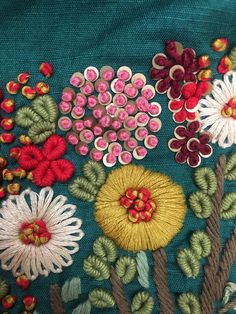 a close up view of some flowers on a green cloth with red and yellow buttons