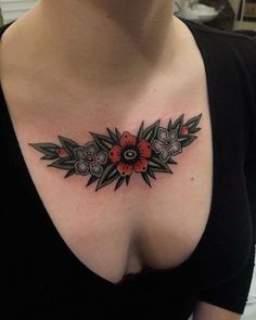 a woman's chest with an artistic tattoo design on her left breast and flowers in the middle