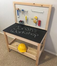 a wooden bench with a chalkboard on it and some construction tools in the back