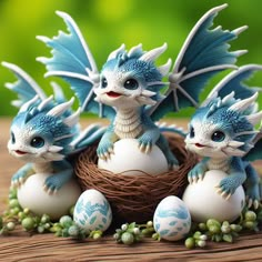 three blue and white dragon figurines sitting on top of eggs in a nest