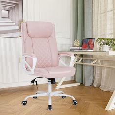 a pink office chair sitting on top of a hard wood floor next to a desk