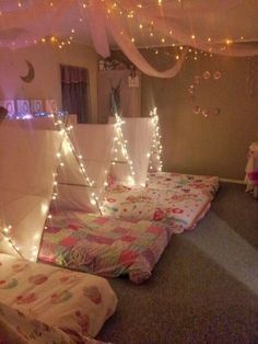 some lights are hanging from the ceiling in a room that is decorated with pink and white sheets