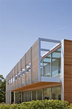 a modern building with wooden slats and glass windows on the top floor is shown