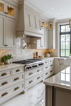 a large kitchen with white cabinets and marble counter tops, along with an island in the middle