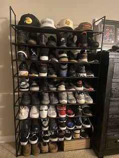 a rack filled with lots of shoes next to a dresser