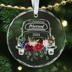 a christmas ornament hanging from a tree with flowers on the front and back