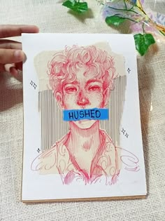 a person holding up a piece of paper with the word hushed on it in front of their face