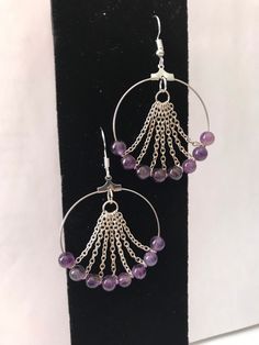 a pair of hoop earrings with purple beads