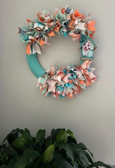 a paper wreath is hanging on the wall next to a potted plant and a clock